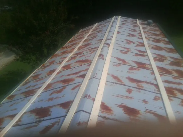 Rusted metal roof panels with new wood purlins before replacement — Storm Damage Roof Repair in Morrisonville by Roofing Brothers