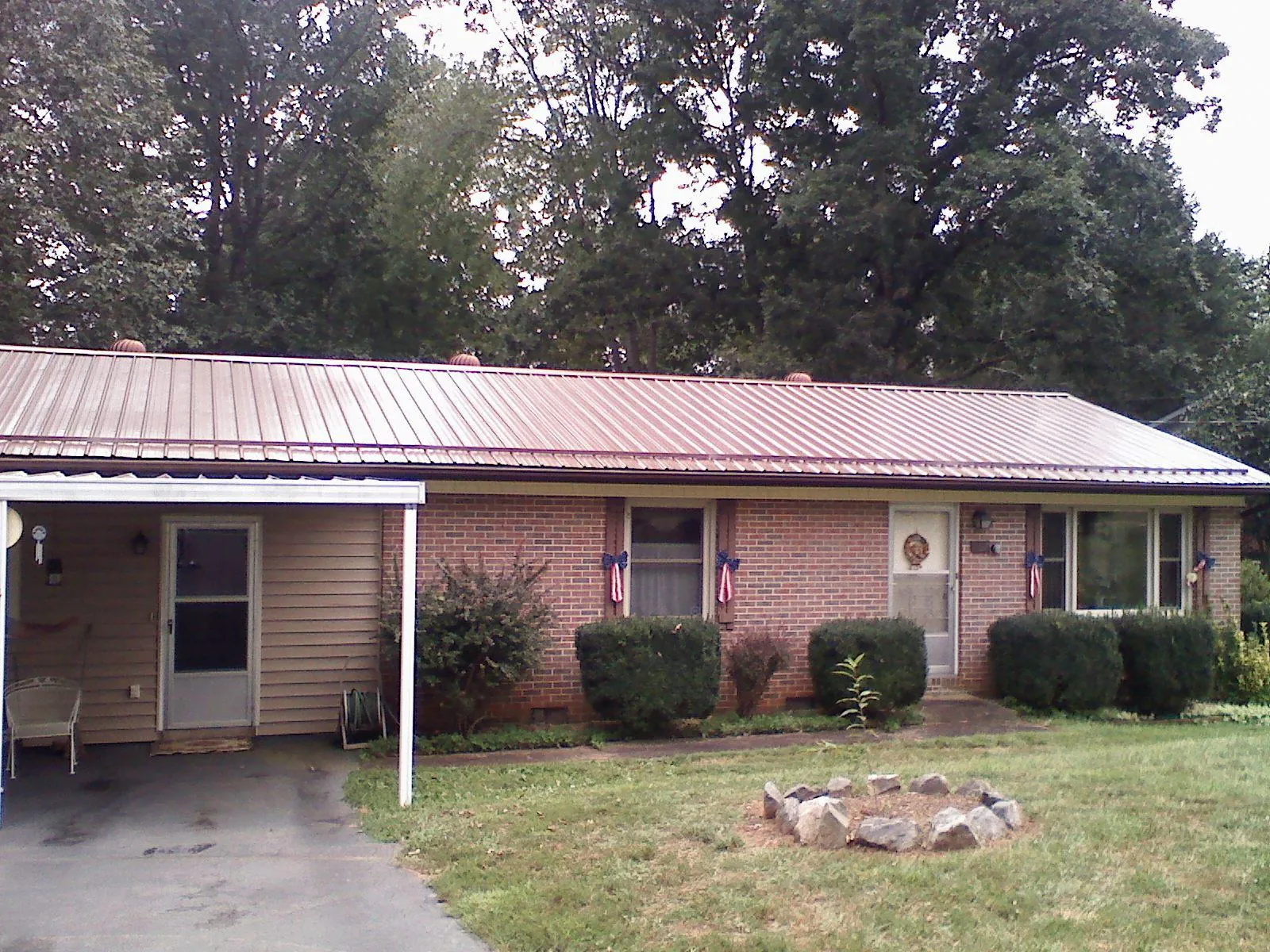 Bronze metal roof and carport on a brick ranch home — Roof Repair work by our crew in Morrisonville